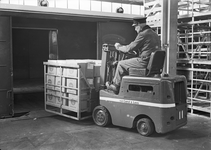 803506 Afbeelding van het beladen van een goederenwagen met behulp van een heftruck in de loods van Van Gend & Loos te ...